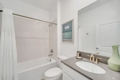 a white bathroom with a sink and a toilet at Amazing Brand New 5BD, Resort Home/Games Room/Pool in Kissimmee