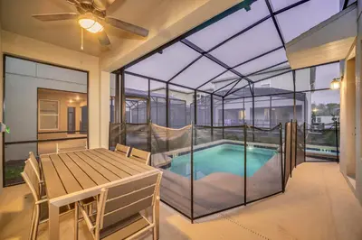 a glass house with a swimming pool and a table at Amazing Brand New 5BD, Resort Home/Games Room/Pool in Kissimmee