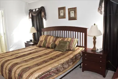 a bedroom with a bed and two night stands and two lamps at 6 bed property - Indian Creek in Kissimmee