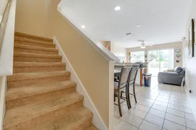 a staircase in a home with a living room and a kitchen at 4 Mi to Disney! Family Townhome with Pool Access in Kissimmee