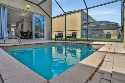a swimming pool in front of a house at 3Q/3B c/piscina 10min to Disney in Orlando