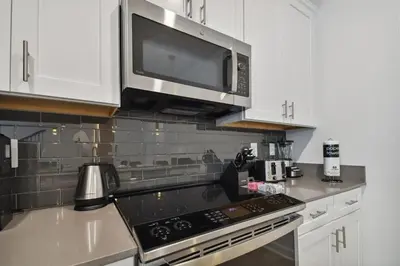 a kitchen with a microwave and a stove top oven at 5Q/4B luxuosa casa *Acesso ao Resort* in Kissimmee