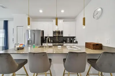 a kitchen with a large counter with four chairs at 5Q/4B luxuosa casa *Acesso ao Resort* in Kissimmee