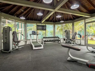 a gym with several exercise bikes in a room with windows at Relaxing 1BR Pirate themed Condo in Orlando Next to Disney with Pool view in Kissimmee