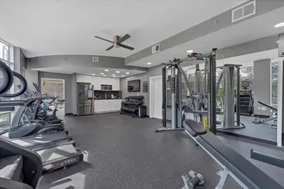 a gym with treadmills and machines and a ceiling fan at Lake Eola Thornton Park Modern 2Bed 2Bath Secure Parking in Orlando