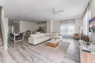 a living room with a white couch and a table at 5BR 10 minutes from Disney Springs SL4800 in Kissimmee