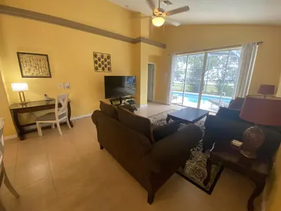 a living room with a couch and a tv and a desk at 2029 Morning in Orlando