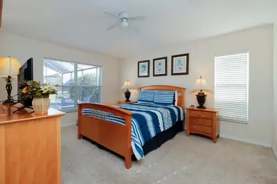 a bedroom with a bed and a dresser and a window at Beautiful Emerald Island Resort Retreat with Private Pool and Spa Close to Disney in Kissimmee