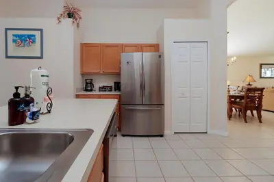a kitchen with a sink and a refrigerator at Beautiful Emerald Island Resort Retreat with Private Pool and Spa Close to Disney in Kissimmee