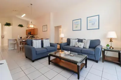 a living room with two blue couches and a table at Beautiful Emerald Island Resort Retreat with Private Pool and Spa Close to Disney in Kissimmee