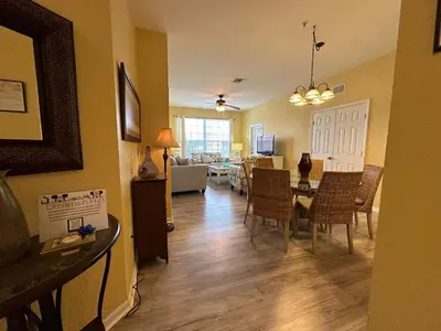 a dining room and living room with a table and chairs at 3Q no Windsor Hills | Perto da Disney + Parque in Orlando