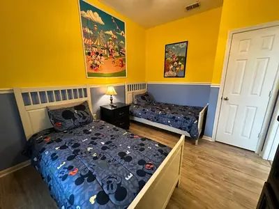 a bedroom with two beds and yellow walls at 3Q no Windsor Hills | Perto da Disney + Parque in Orlando