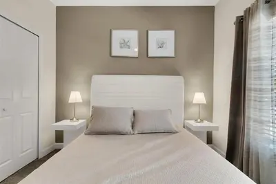 a bedroom with a large bed with two lamps on both sides at 5Q/4B Storey Lake * c/ Piscina * in Kissimmee