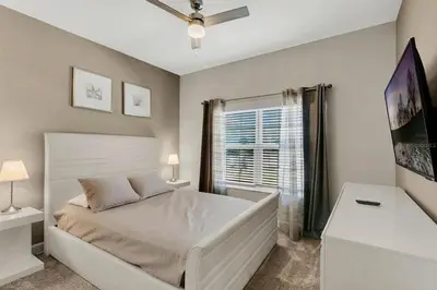 a bedroom with a white bed and a window at 5Q/4B Storey Lake * c/ Piscina * in Kissimmee
