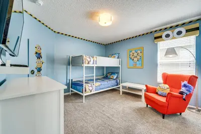 a childs room with a bed and a chair at 5 Mi to Disney Ideal Family Getaway with Theater! in Kissimmee
