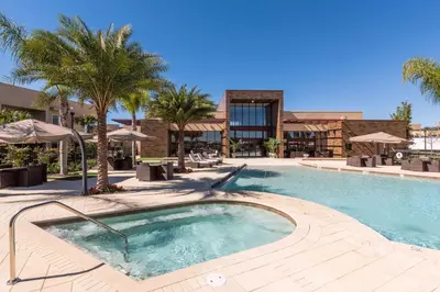a swimming pool with palm trees and a building at Magic Village Yards Trademark Collection by Wyndham in Orlando