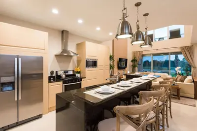 a kitchen and dining room with a long table with chairs at Magic Village Yards Trademark Collection by Wyndham in Orlando