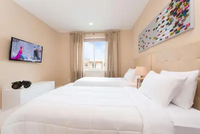 a hotel room with two beds and a tv at Magic Village Yards Trademark Collection by Wyndham in Orlando