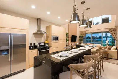 a kitchen and dining room with a large table with chairs at Magic Village Yards Trademark Collection by Wyndham in Orlando