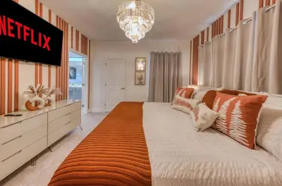 a bedroom with a large bed and a chandelier at Experience Luxury in Your 11 En-Suites Mansion in Orlando