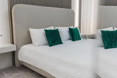 a bed with green and white pillows on it at Brand NEW 10Bedrooms At Paradiso Grande in Orlando