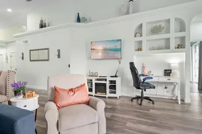 a living room with a chair and a desk at Single-Level Home w Heated Pool & 9MI to Disney in Orlando