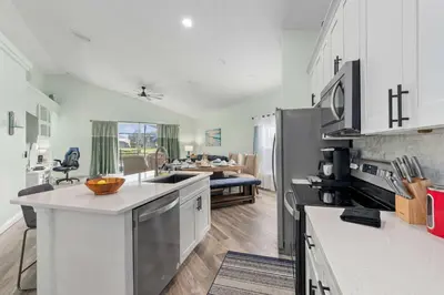 a kitchen with white cabinets and a living room at Single-Level Home w Heated Pool & 9MI to Disney in Orlando
