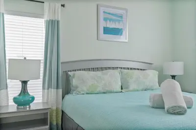 a bedroom with a bed with blue sheets and a window at Single-Level Home w Heated Pool & 9MI to Disney in Orlando