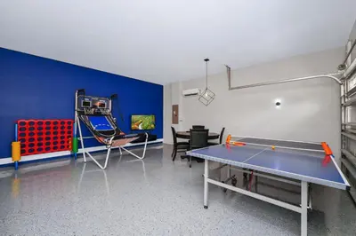 a room with a ping pong table in a room with at Charming Home Near Disney With Private Pool, Game Room And Waterpark & Resort Access At Encore Resorts Reunion - 410No in Kissimmee