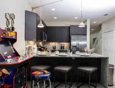 a kitchen with a large counter with stools in it at Clermont Family Townhouse Pool & Arcade near Disney in Orlando