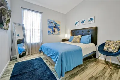a bedroom with a bed with blue sheets and a mirror at Making Memories Resort -Windsor Palms Villa in Kissimmee