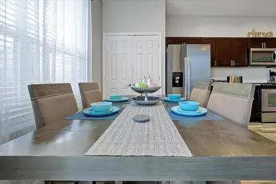 a dining room table with blue dishes and a refrigerator at Making Memories Resort -Windsor Palms Villa in Kissimmee