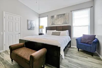 a bedroom with a bed and a blue chair at Making Memories Resort -Windsor Palms Villa in Kissimmee