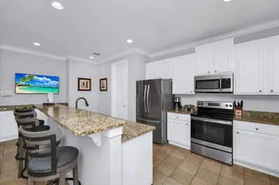 a kitchen with white cabinets and stainless steel appliances at Glorious Home Near Disney With Game Room, Themed Rooms, Waterpark & Resort Access At Encore Resorts Reunion - 7643Wi in Kissimmee