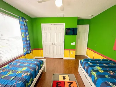 a childs bedroom with two beds and green walls at Casa Épica de 6 Quartos | Quarto dos Vingadores + Piscina in Orlando