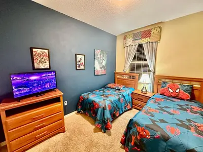 a bedroom with two beds and a flat screen tv at Grand Luxury 3BR Townhouse Near Disney Parks in Kissimmee