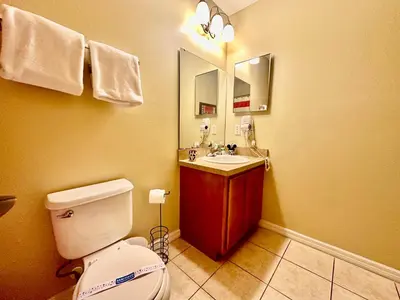 a bathroom with a white toilet and a sink at Grand Luxury 3BR Townhouse Near Disney Parks in Kissimmee