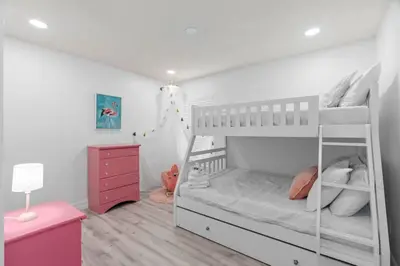 a bedroom with a white bunk bed with a ladder at Tropical 7BR Heated Pool Pet Friendly Disney in Kissimmee