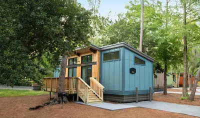 a tiny house in a park with a tree at The Cabins at Disney's Fort Wilderness Resort in Orlando