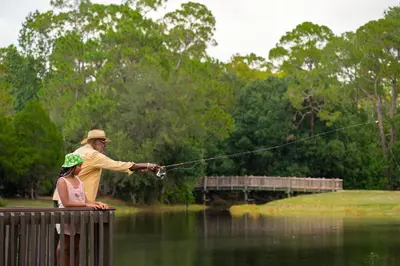 a man standing on a dock fishing with a girl at The Cabins at Disney's Fort Wilderness Resort in Orlando
