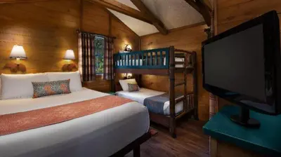 a bedroom with a bed and a flat screen tv at The Cabins at Disney's Fort Wilderness Resort in Orlando