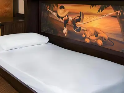 a bed with a painting on the side of it at Disney's Caribbean Beach Resort in Orlando