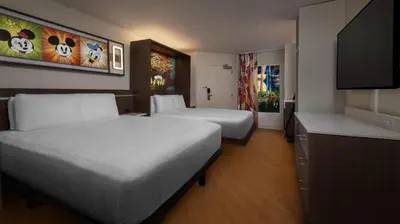 a hotel room with two beds and a flat screen tv at Disney's All-Star Movies Resort in Orlando