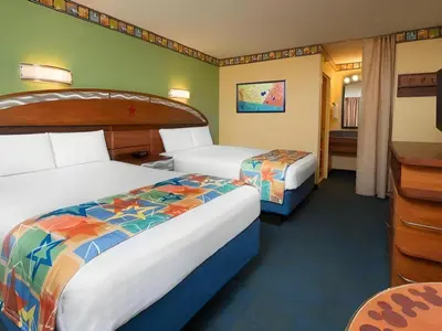 a hotel room with two beds and a desk at Disney's All-Star Movies Resort in Orlando