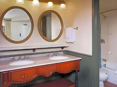 a bathroom with two sinks and two mirrors at Disney's Port Orleans Resort - French Quarter in Orlando