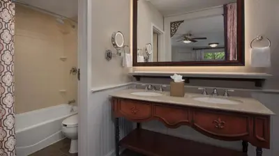 a bathroom with two sinks and a mirror at Disney's Port Orleans Resort - French Quarter in Orlando