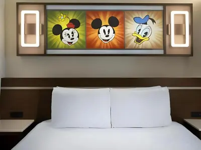a bedroom with a bed with a painting of pandas at Disney's All-Star Sports Resort in Orlando