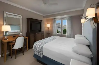 a hotel room with a bed and a desk and a television at Disney's Beach Club Resort in Orlando