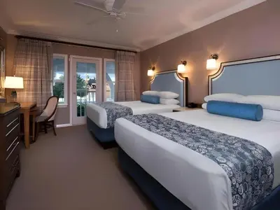 a hotel room with two beds and a desk at Disney's Beach Club Resort in Orlando