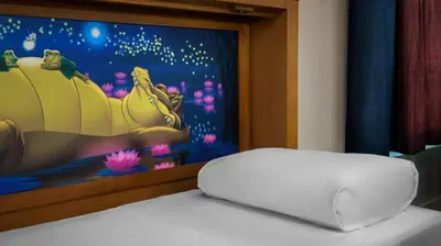 a white laptop computer sitting on top of a bed at Disney's Port Orleans Resort - Riverside in Orlando